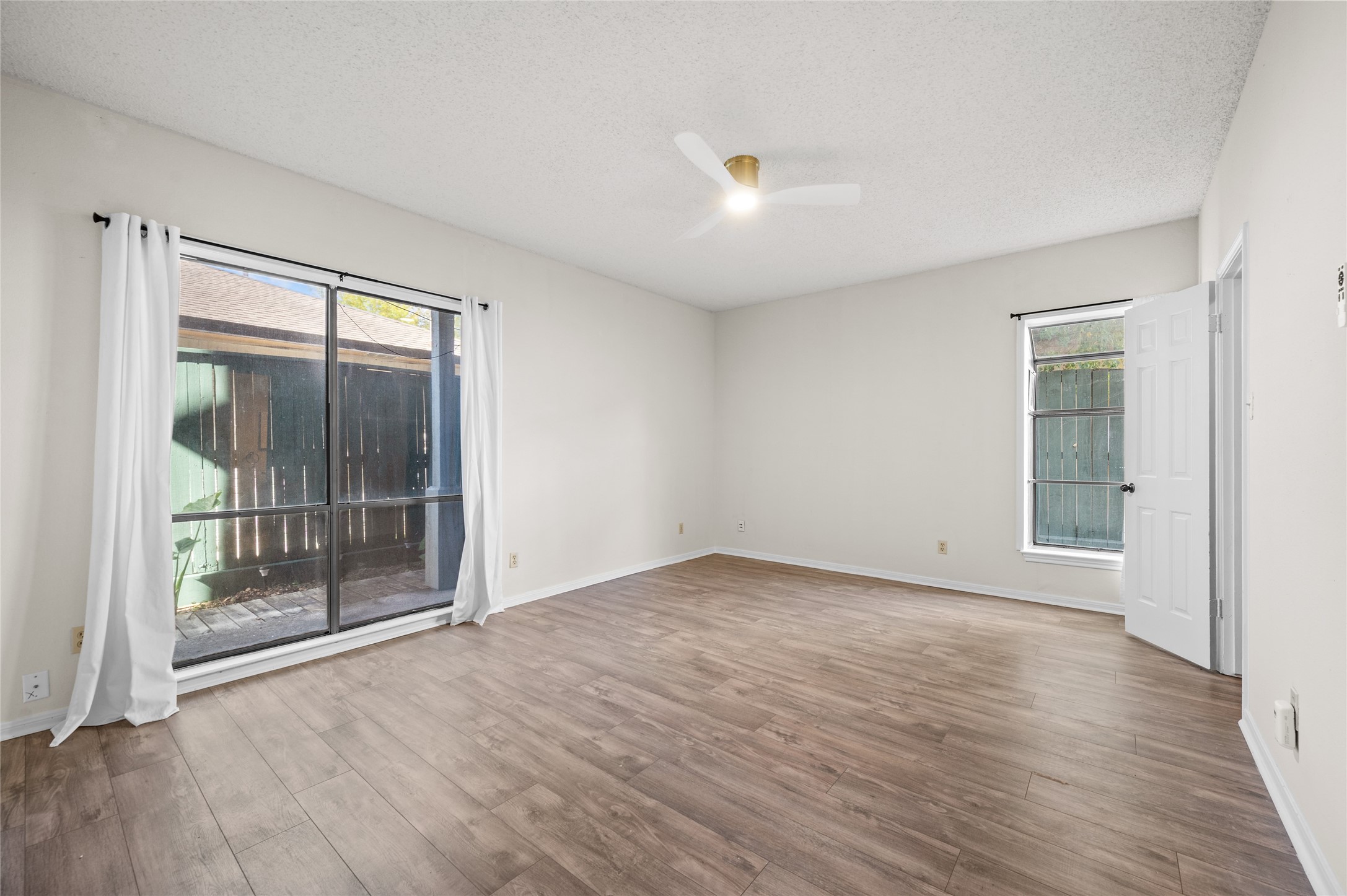 5718 Val Verde Street, Unit 7 Houston, TX 77057 - Photo 9 of 23 an empty room with wooden floor and windows