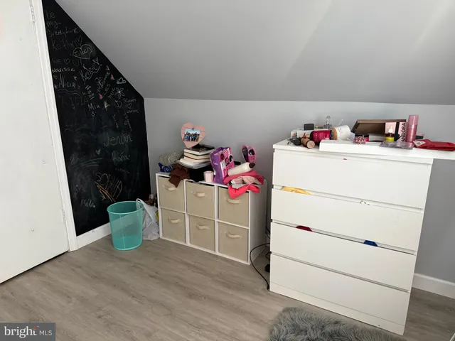 a room with a baby crib and dresser