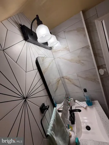 a bathroom with a sink and mirror with bathtub