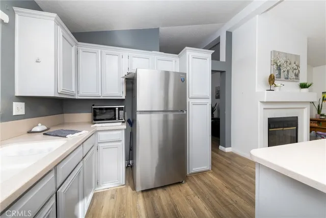 a kitchen with a refrigerator sink and cabinets