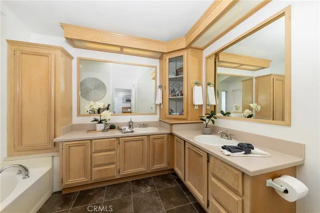 a bathroom with a sink and mirror with bathtub