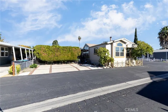 a front view of a house with a garden and mountain view