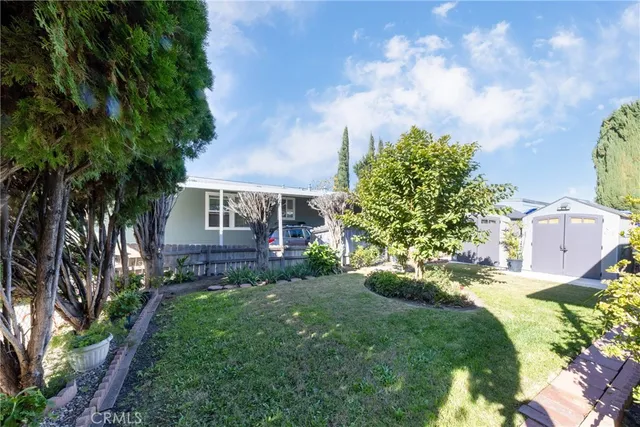 a view of a house with a yard and potted plants