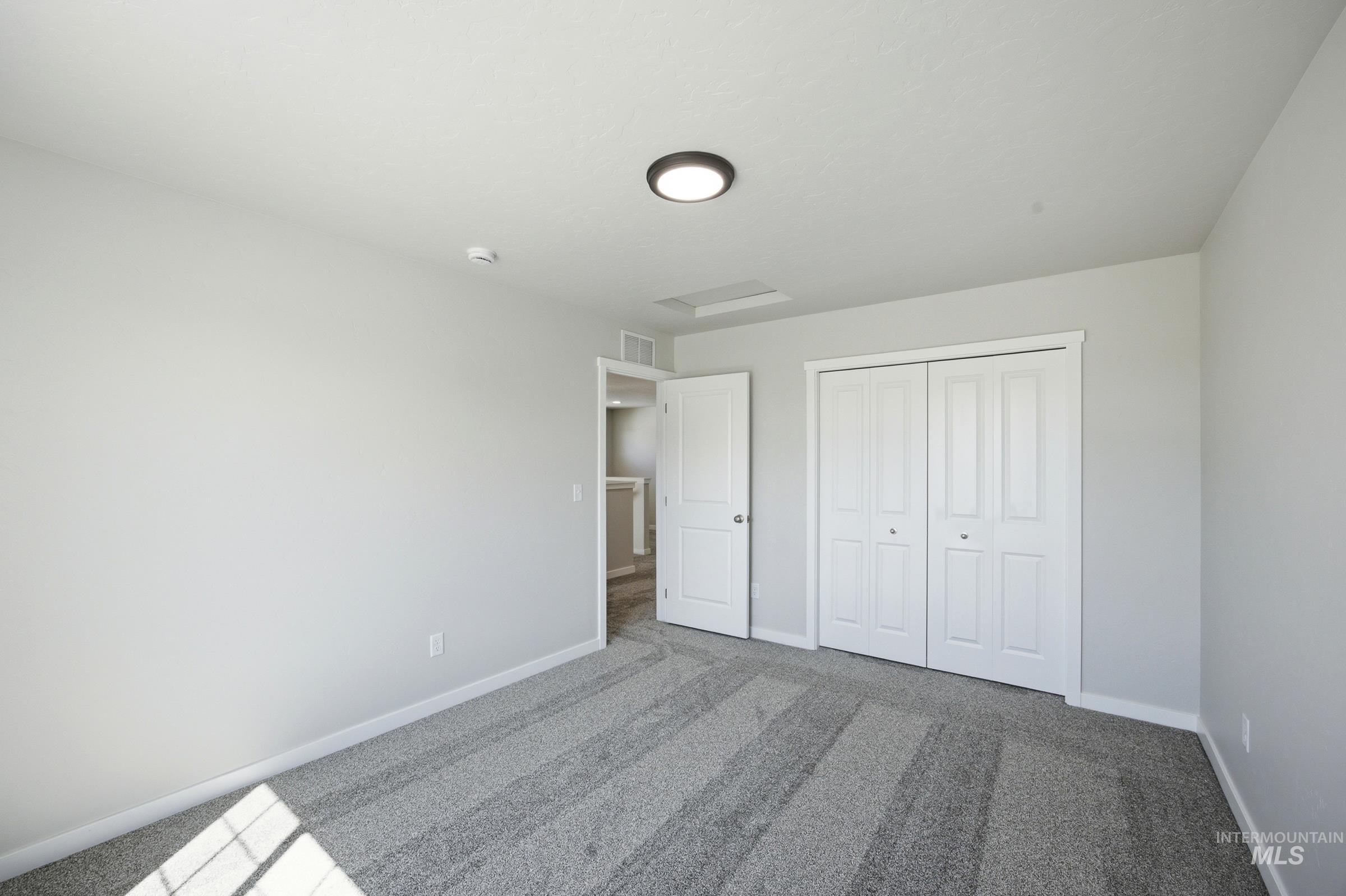 13333 Bank Street Caldwell, ID 83607 - Photo 29 of 29 Plush patterned carpeting, neutral wall finishes, flush-mount ceiling light fixture, and white bi-fold closet doors