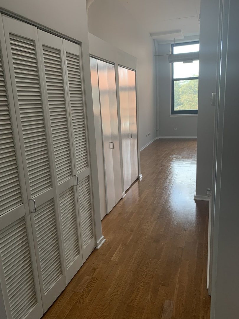 2323 West Pershing Road, Unit 319 Chicago, IL 60609 - Photo 25 of 39 an empty room with wooden floor and windows