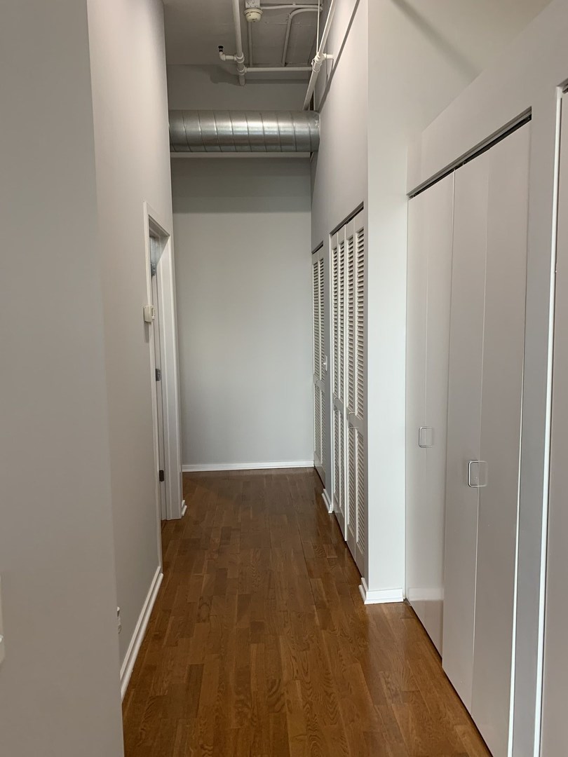 2323 West Pershing Road, Unit 319 Chicago, IL 60609 - Photo 27 of 39 a view of a hallway with wooden floor