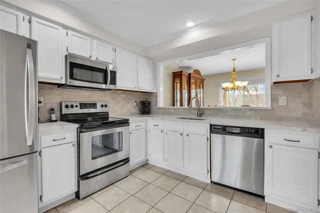 a kitchen with white cabinets stainless steel appliances and sink
