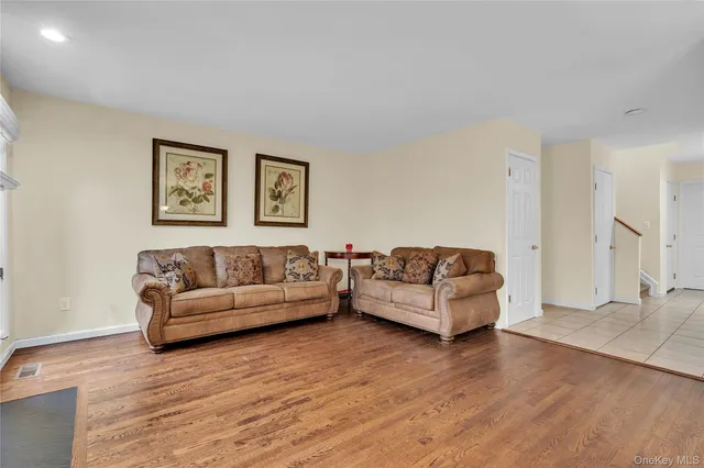 a living room with couches and a night stand