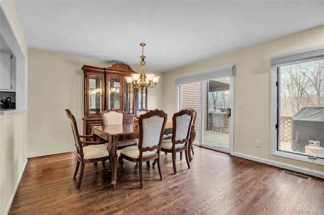 a view of a a dining room with furniture window and wooden floor