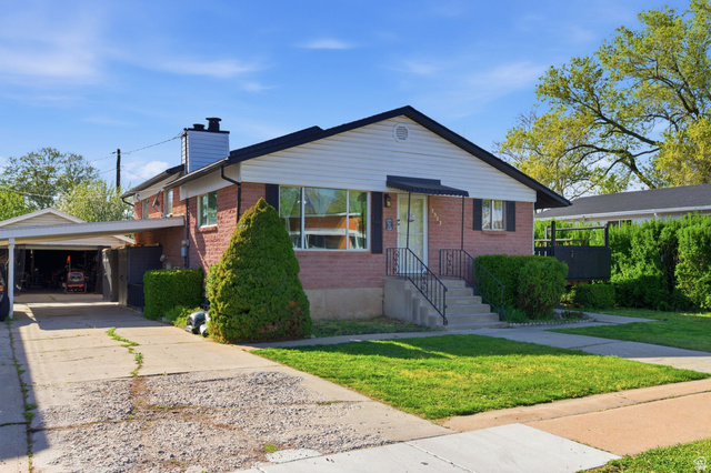 2323 North 720 West Clinton, UT 84015 - Photo 31 of 34 Bungalow-style home with brick siding, a chimney, a front yard, driveway, and an attached carport