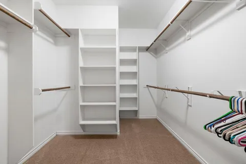 a view of walk in closet with empty racks