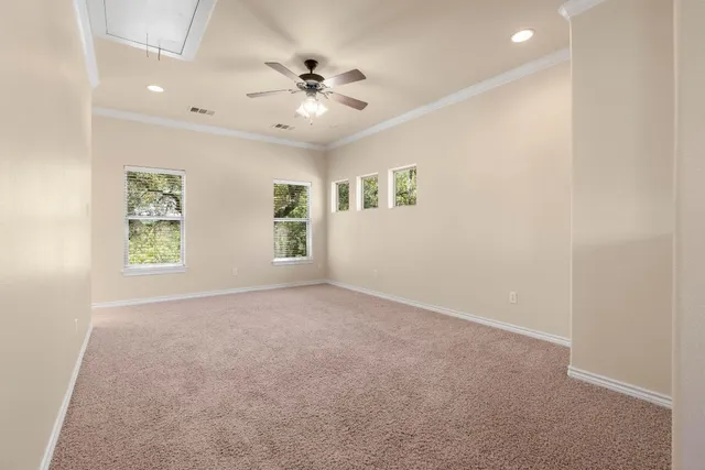 an empty room with windows and fan