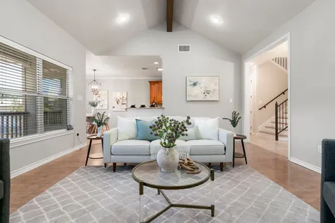 a living room with furniture potted plant and a large window