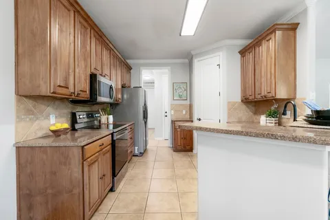 a kitchen with stainless steel appliances granite countertop a stove a sink and a microwave