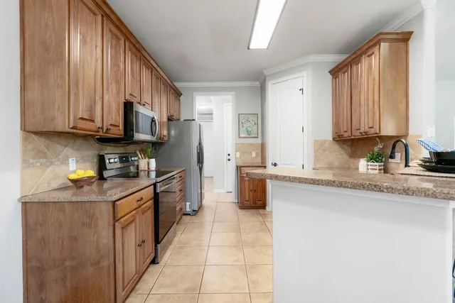 a kitchen with stainless steel appliances granite countertop a stove a sink and a microwave