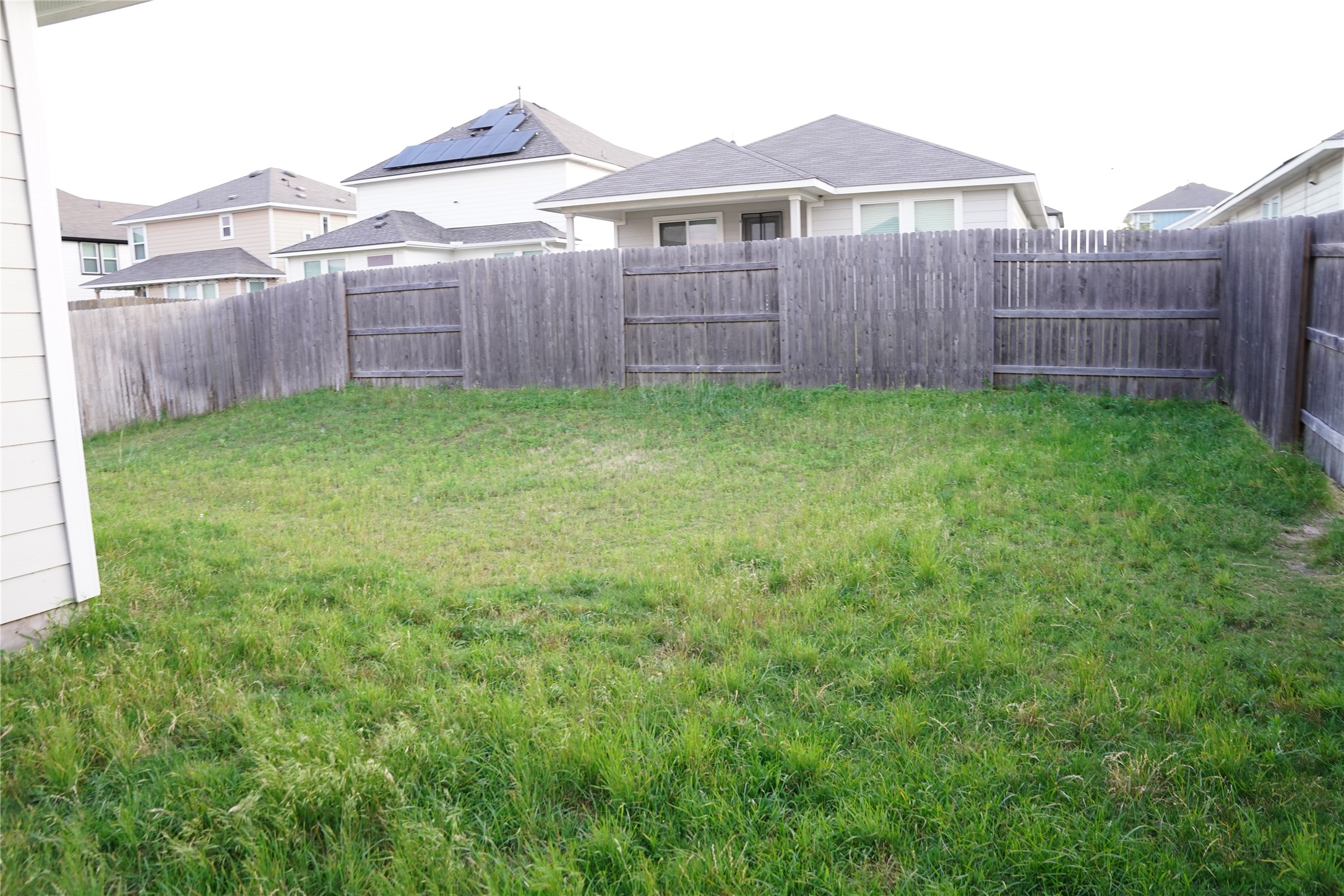 117 Crescent Street Georgetown, TX 78626 - Photo 22 of 38 A well-maintained wooden fence encloses a generously sized backyard, ready for personalization.