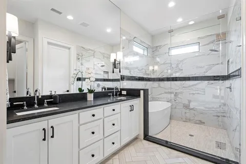 a bathroom with a double vanity sink mirror and shower