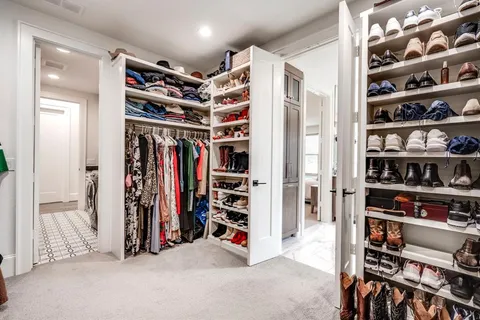 a view of walk in closet with clothes and shoes