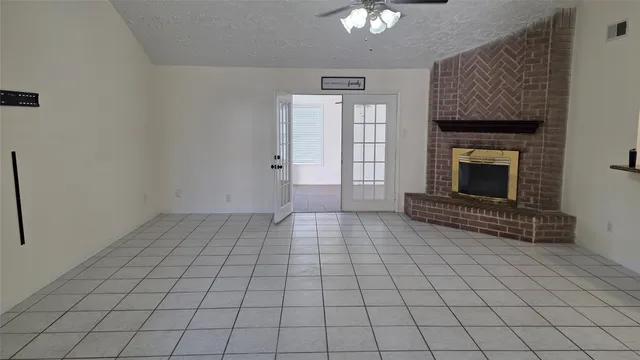 an empty room with windows and fireplace