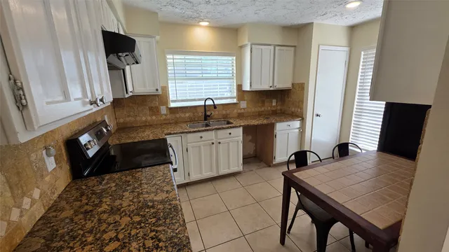 a kitchen with a sink a table and chairs in it