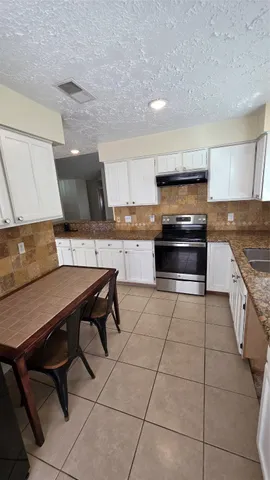 a kitchen with a stove a sink and a microwave