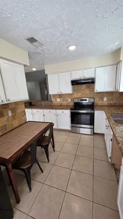 a kitchen with a stove a sink and a microwave