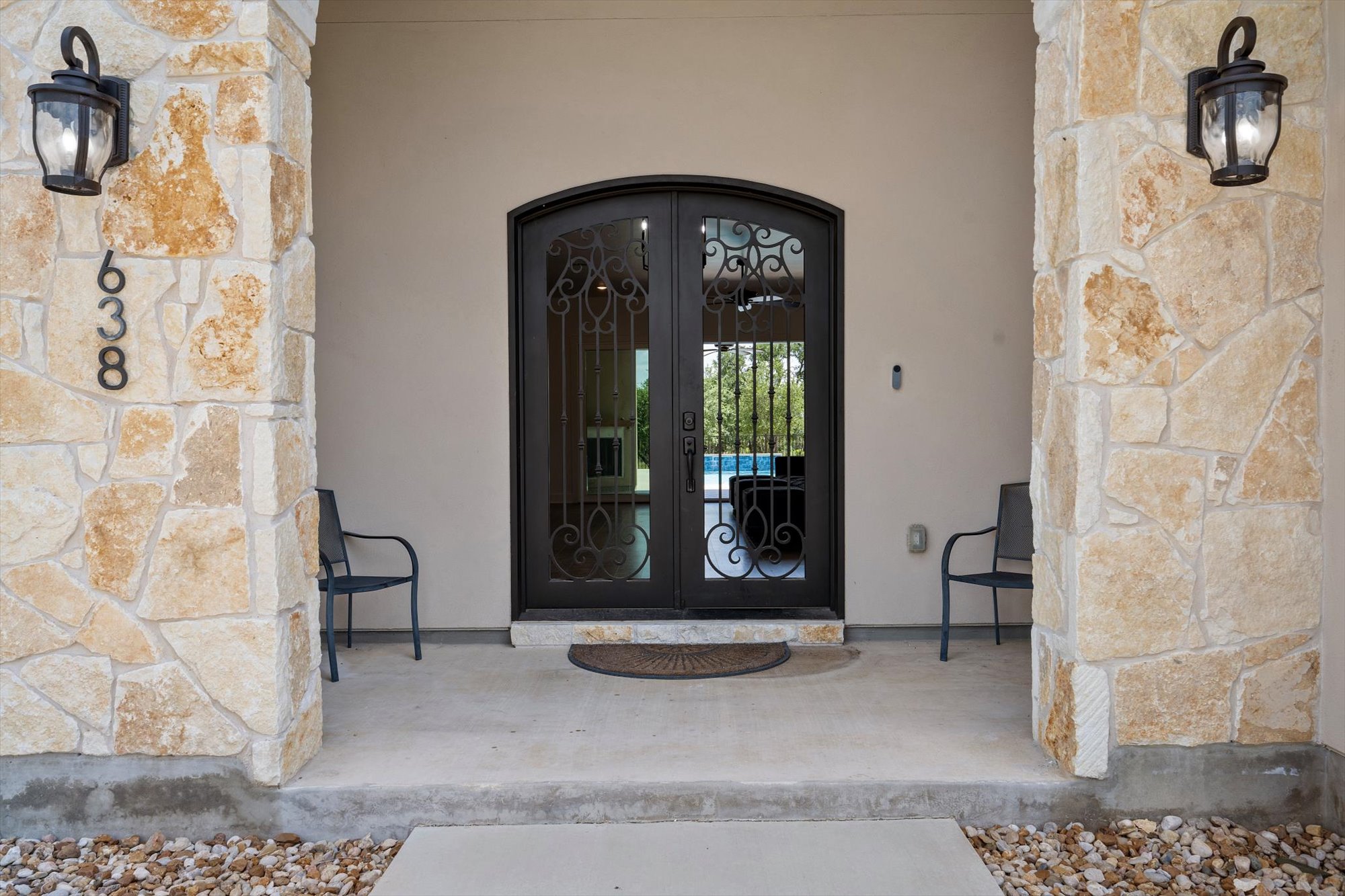 638 Strada Luca Florence, TX 76527 - Photo 7 of 38 Ornate wrought iron double doors grace the stone-clad entrance, promising grand interiors beyond.