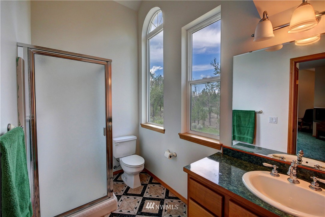 36 Beaver Pond Road Twisp, WA 98856 - Photo 32 of 40 a bathroom with a granite countertop sink a toilet and a mirror