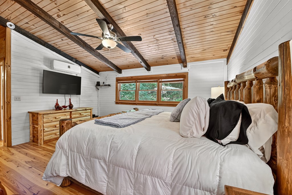 100 Stanley Creek Road Cherry Log, GA 30522 - Photo 57 of 81 a bedroom with a large bed a flat tv screen and a walk in closet