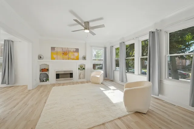 a spacious bedroom with a large bed a fireplace and windows
