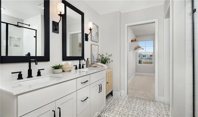 a bathroom with a double vanity sink a mirror and a bathtub