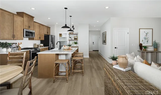 a living room with furniture a flat screen tv and kitchen view