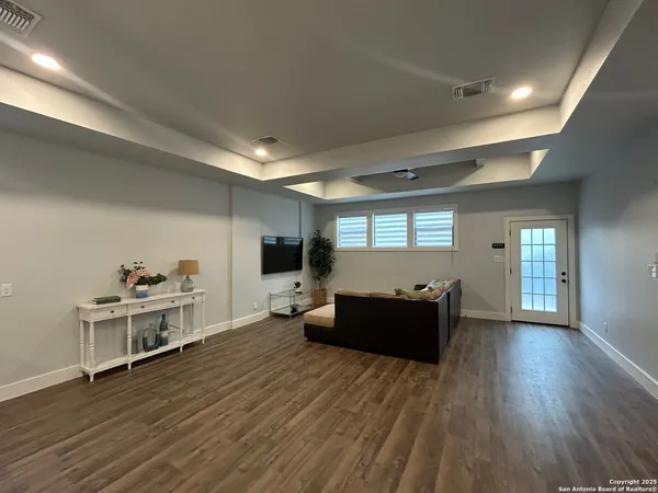 a living room with furniture and a wooden floor