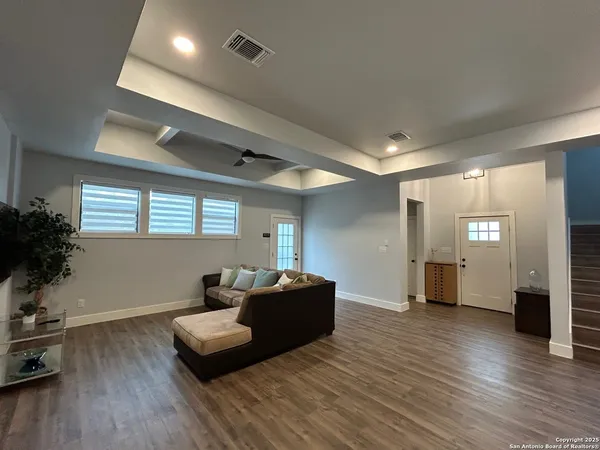 a living room with furniture and a wooden floor