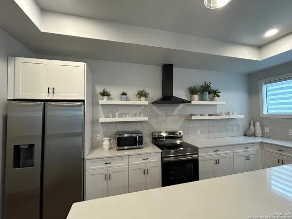 a kitchen with a refrigerator sink and cabinets