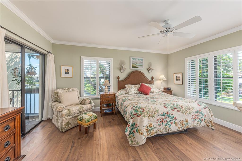 3901 Southeast St Lucie Boulevard, Unit 34 Stuart, FL 34997 - Photo 11 of 58 a bedroom with a bed and wooden floor
