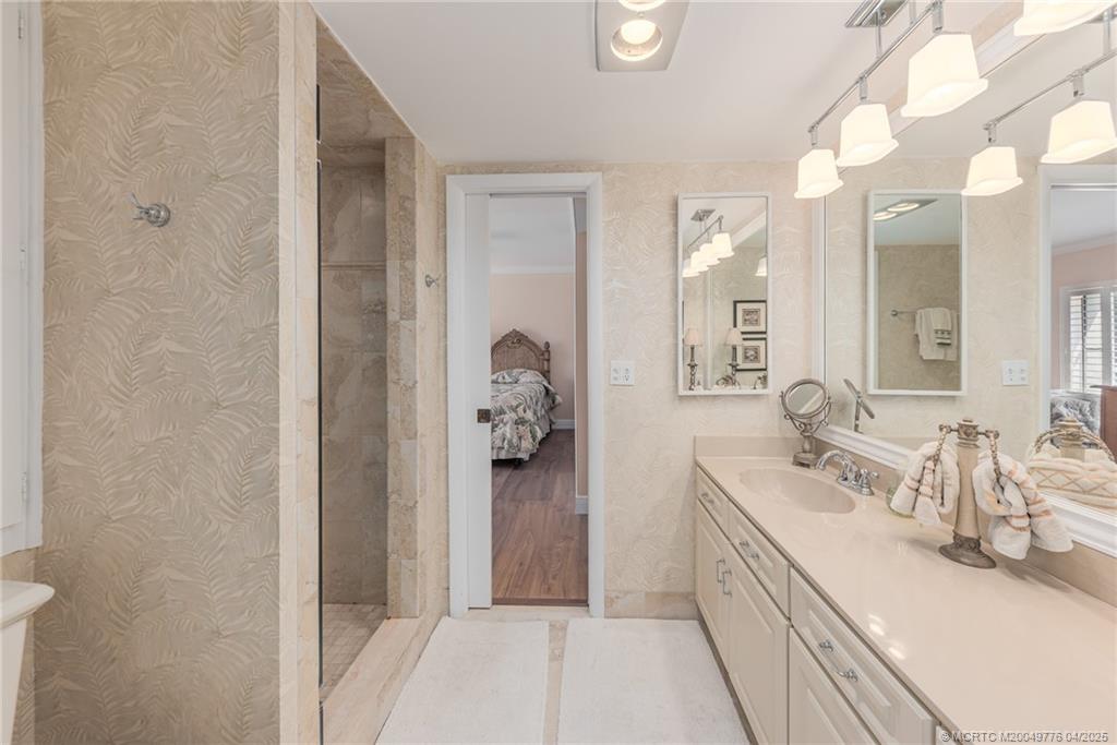 3901 Southeast St Lucie Boulevard, Unit 34 Stuart, FL 34997 - Photo 14 of 58 a spacious bathroom with a double vanity sink and mirror