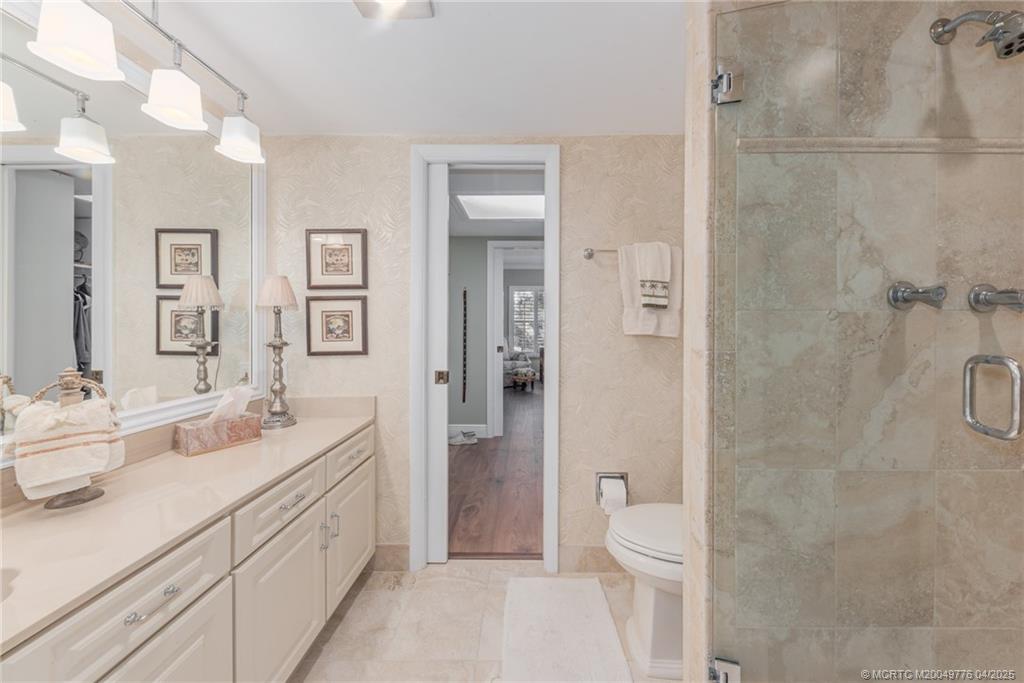 3901 Southeast St Lucie Boulevard, Unit 34 Stuart, FL 34997 - Photo 15 of 58 a bathroom with a double vanity sink toilet and shower
