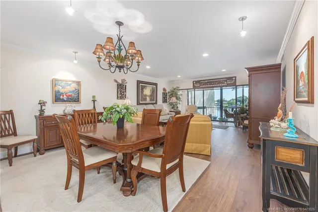 a view of a dining room with furniture a chandelier and wooden floor