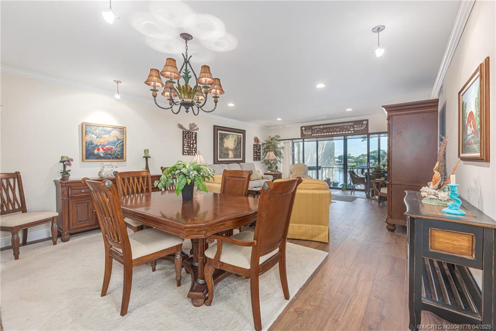 3901 Southeast St Lucie Boulevard, Unit 34 Stuart, FL 34997 - Photo 4 of 58 a view of a dining room with furniture a chandelier and wooden floor