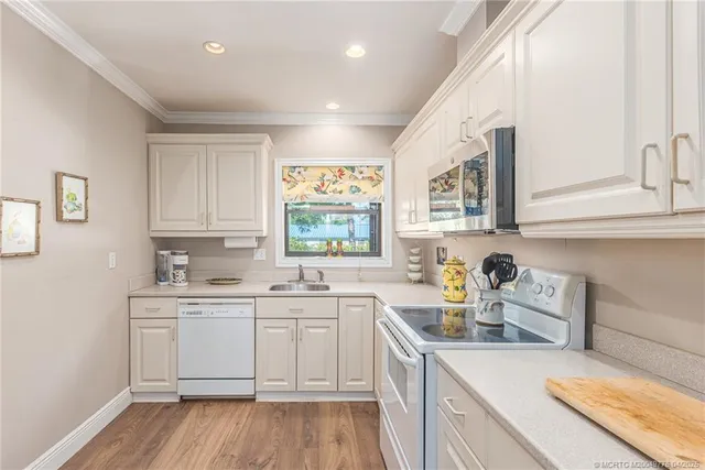 a kitchen with white cabinets and white appliances