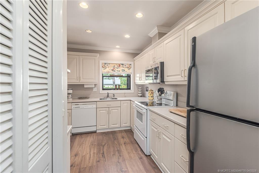 3901 Southeast St Lucie Boulevard, Unit 34 Stuart, FL 34997 - Photo 10 of 58 a kitchen with white cabinets and white appliances