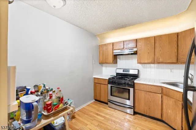 a kitchen with a sink a stove and cabinets