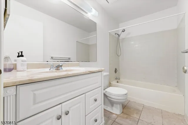 a bathroom with a granite countertop sink a toilet and a bathtub