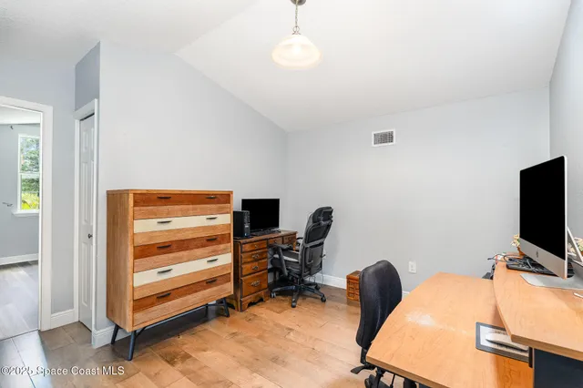 a view of a workspace with furniture and a window