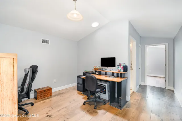 a view of a workspace with furniture and a window