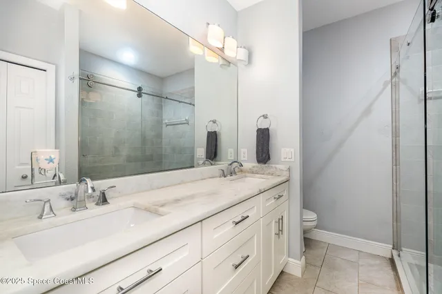 a bathroom with a granite countertop sink a toilet and a mirror