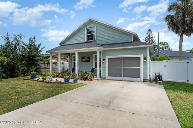 a front view of a house with yard and a garage
