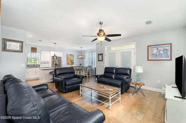 a living room with furniture and a flat screen tv with wooden floor