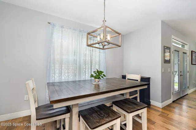 a view of dining table and chairs in kitchen with wooden floor